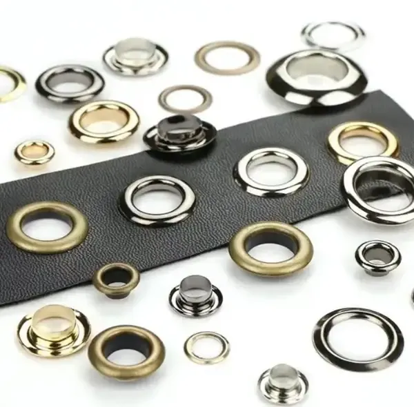 A tray of metal grommets, eyelets and studs in brass, nickel and black finishes