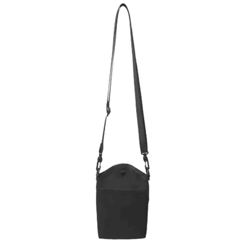 A small black leather bucket bag hanging from a long thin strap against a pale grey ground