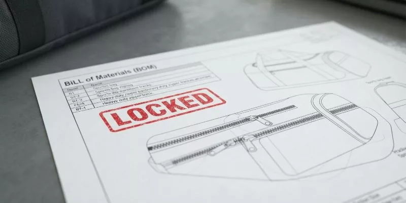 Locked Bill of Materials and tech pack for custom team sports bags on a factory desk.