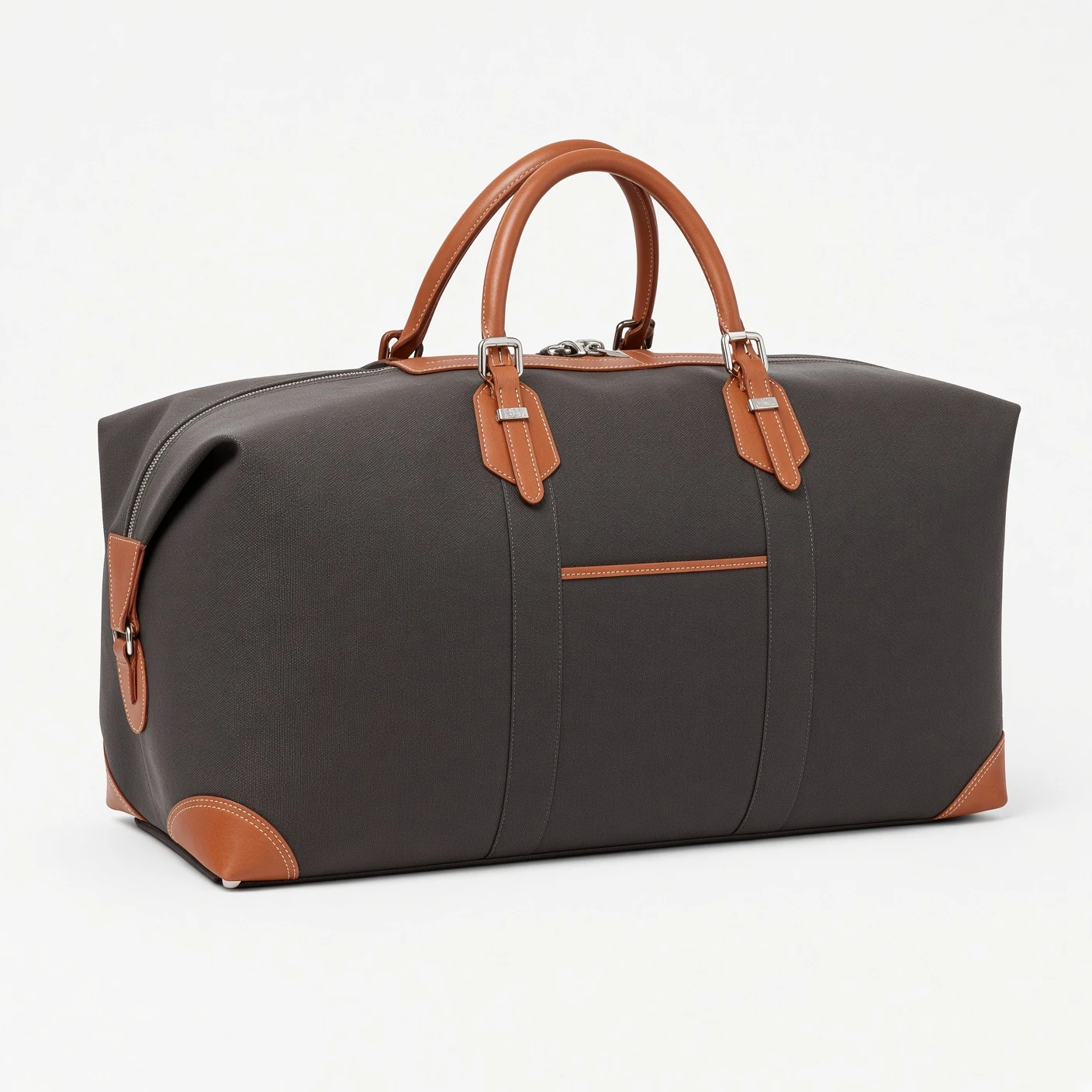 A dark leather-trimmed luxury duffle bag with tan handles, metal buckle hardware and tan leather corner patches