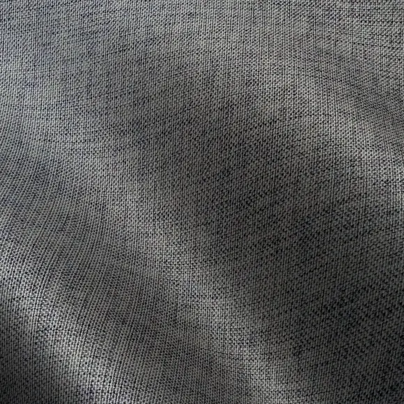 A close view of charcoal polyester, its fine matte weave and soft folds catching the light