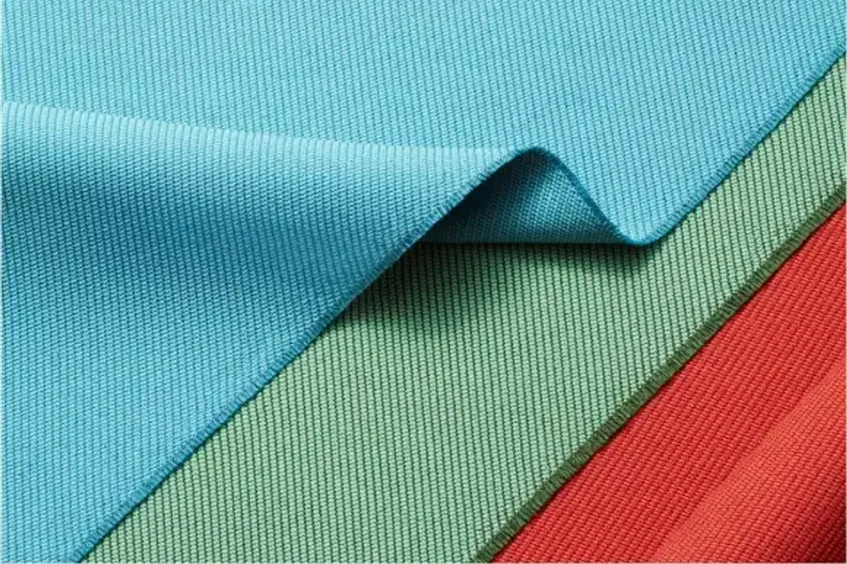 Folded lengths of RPET recycled polyester in yellow, blue, green and red