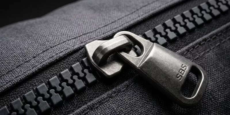 Heavy-duty SBS #10 molded zipper with a thick metal pull tab on a duffle bag.