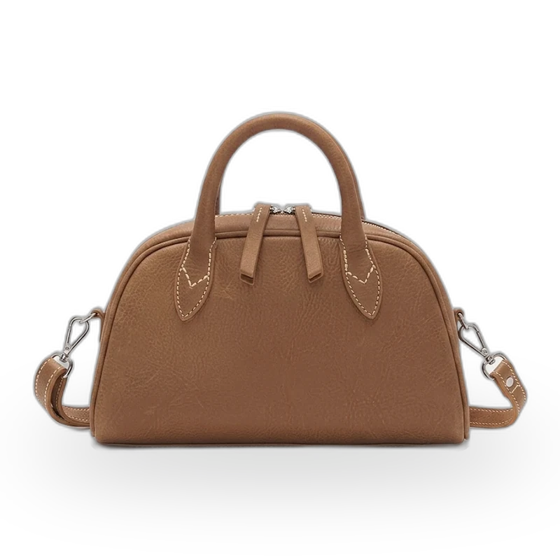 A tan leather mini handbag with a top handle and crossbody strap