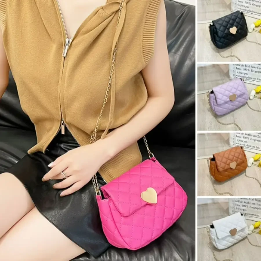 A pink quilted leather crossbody bag with a heart-shaped clasp, worn with a chain strap