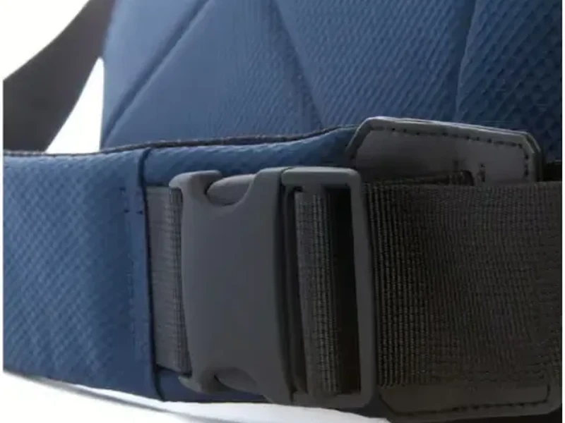 A close view of a blue messenger bag showing the webbing strap run through a side-release buckle