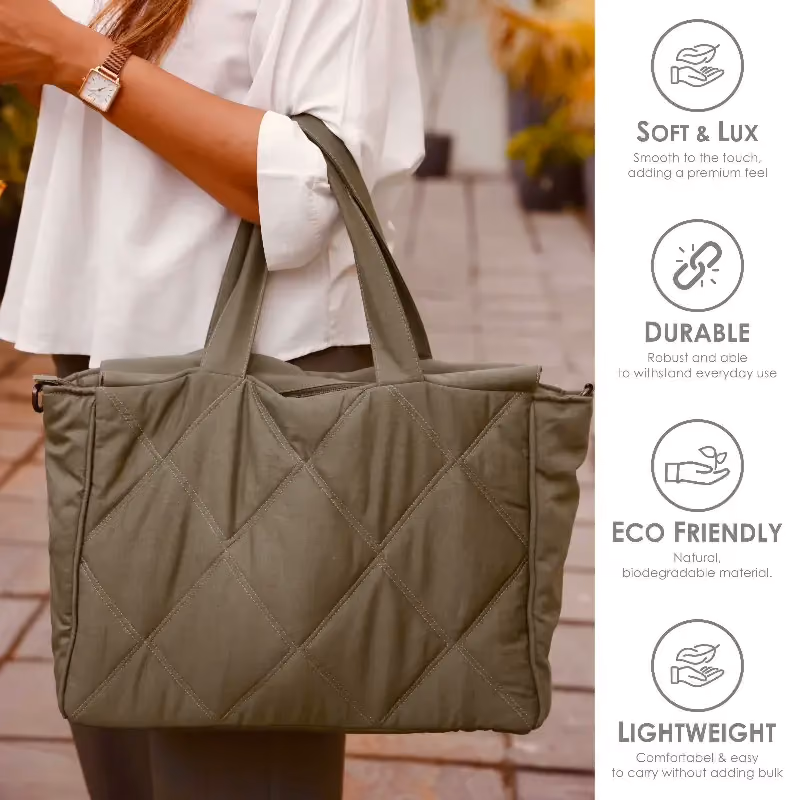 An olive quilted tote carried on the arm against a garden wall