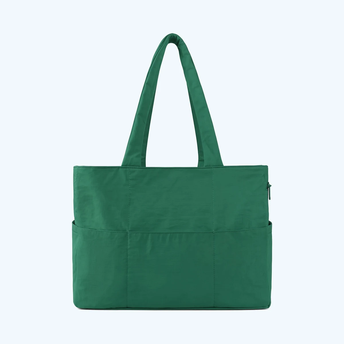 A green reversible tote bag shown from the side, with an external slip pocket