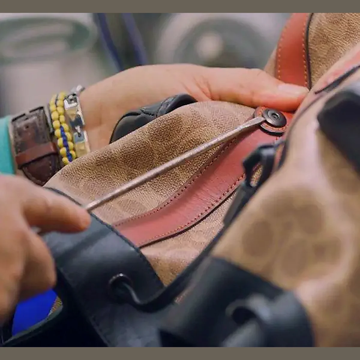 Hands adjusting the shoulder strap and press-stud of a custom travel bag