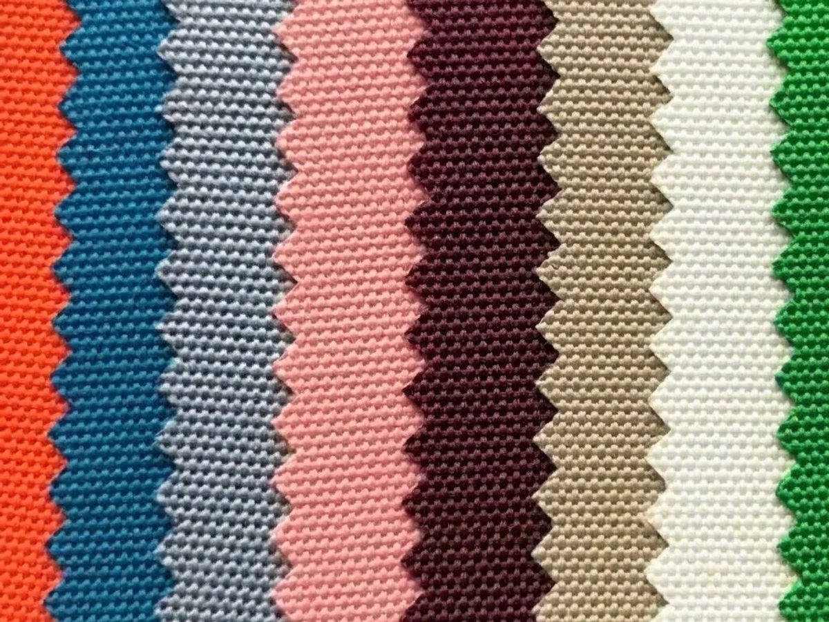 A fan of coated polyester webbing swatches in a range of printed colours